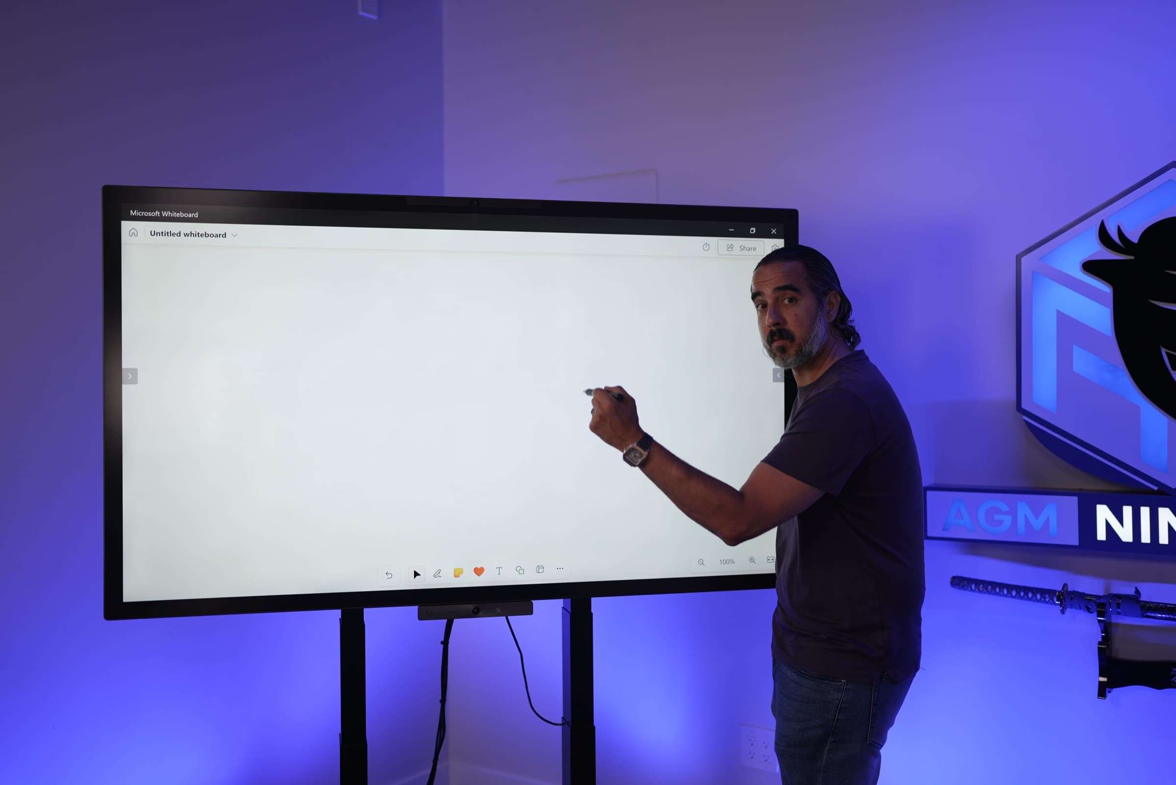 Manuel drawing on the studio's interactive whiteboard, pen in hand