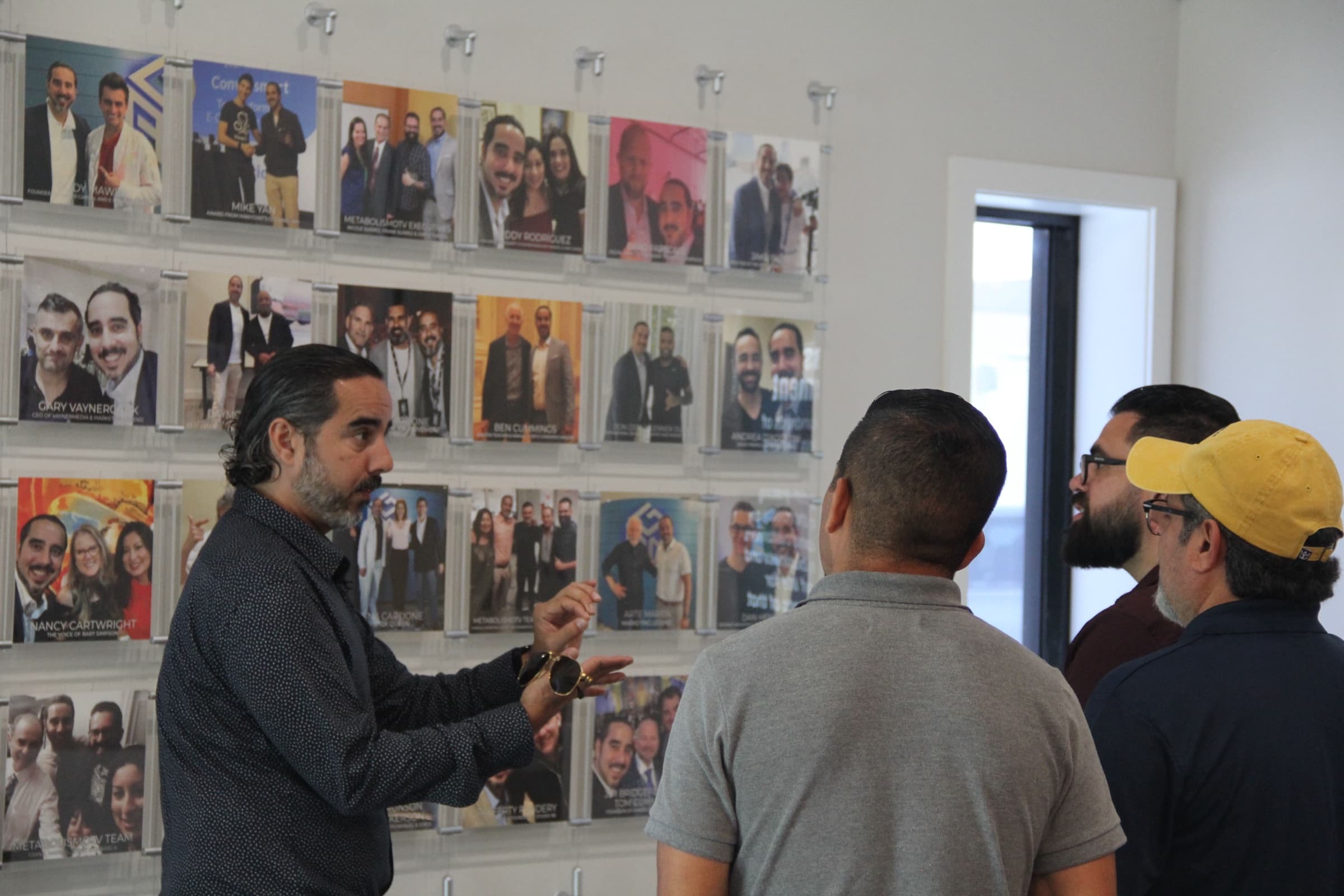Manuel Suarez presenting the wall of client photos to visitors