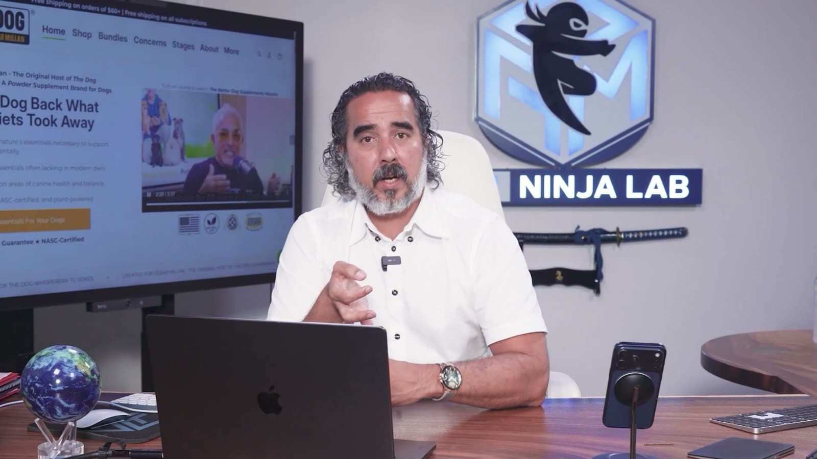 Manuel mid-explanation at the Ninja Lab desk, client storefront up on the studio screen