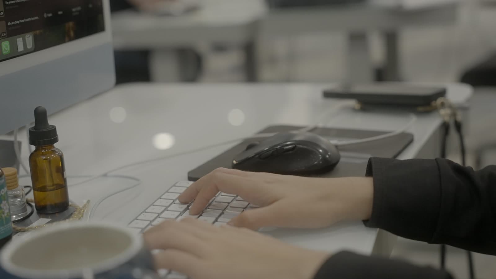 Hands at an AGM workstation keyboard, store operations in motion